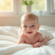 Bébé nouveau-ne souriant sur une couverture blanche
